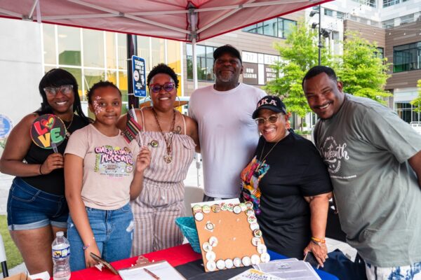 group of people smiling holding Juneteenth flags