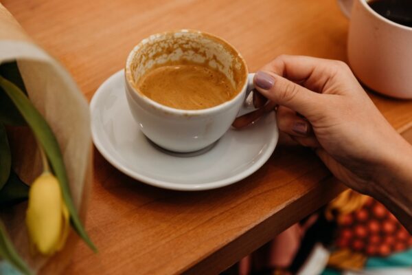 hand holding a mug of coffee with flowers
